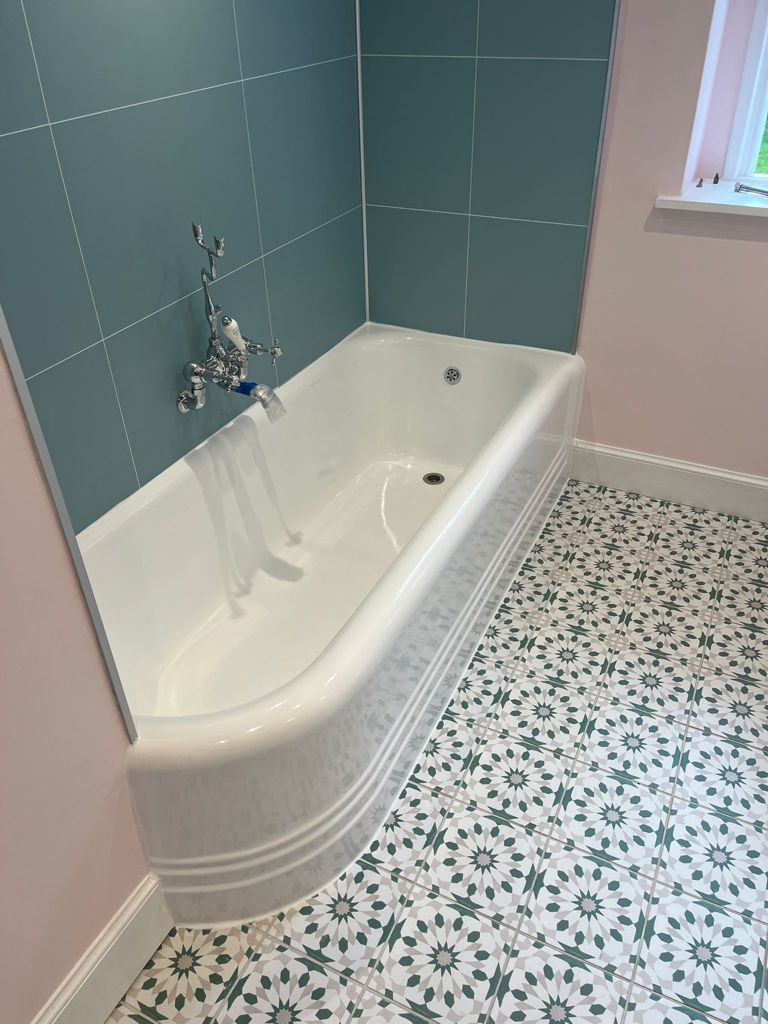 A restored built-in bath in a refreshed tiled bathroom